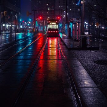 photo of tram beside waiting station during nighttime