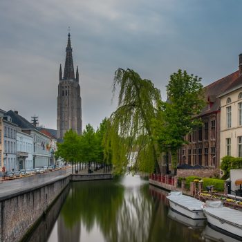 boats on river surrounded with building at daytime