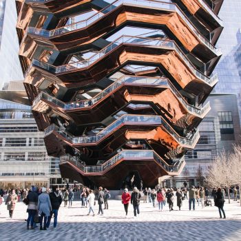 people on park below the giant sculpture